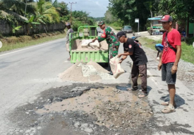 Babinsa dan Masyarakat Gotong Royong Perbaiki Jalan Rusak di Desa Riam Durian